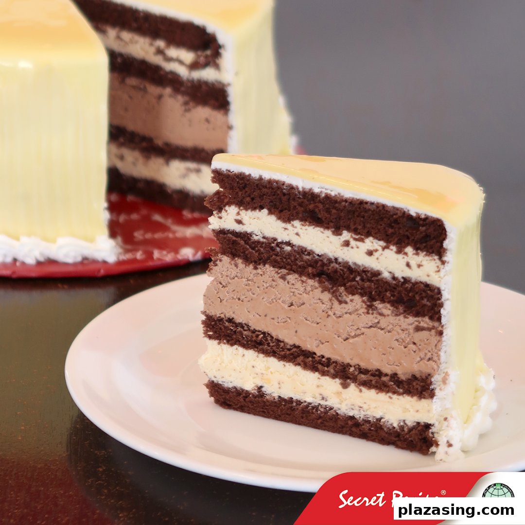 A delicious slice of multi-layered chocolate and cream cake with a glossy white chocolate glaze.