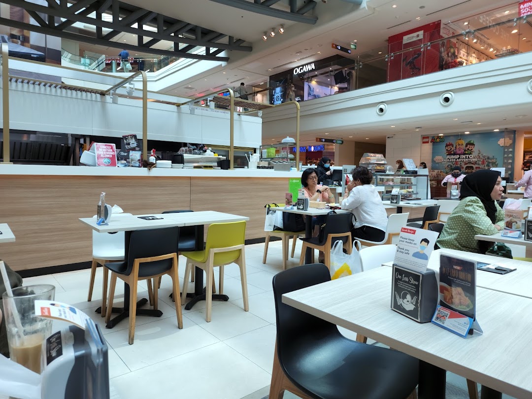 Interior view of Secret Recipe cafe with customers dining and a service counter.