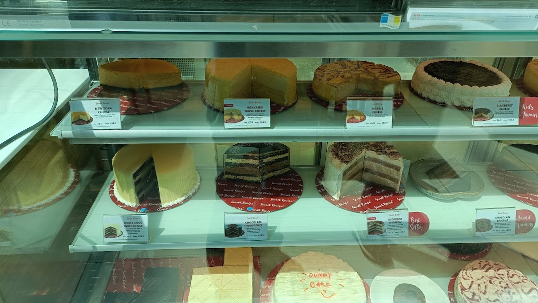A vibrant display case showcasing a variety of delicious cakes and cheesecakes at Secret Recipe.