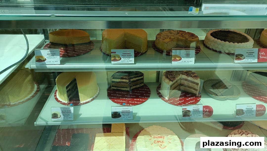 A vibrant display case showcasing a variety of delicious cakes and cheesecakes at Secret Recipe.