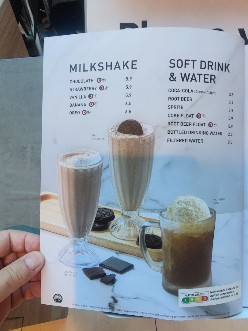A menu page displaying milkshakes, soft drinks, and water options with prices and Nutri-Grade information.