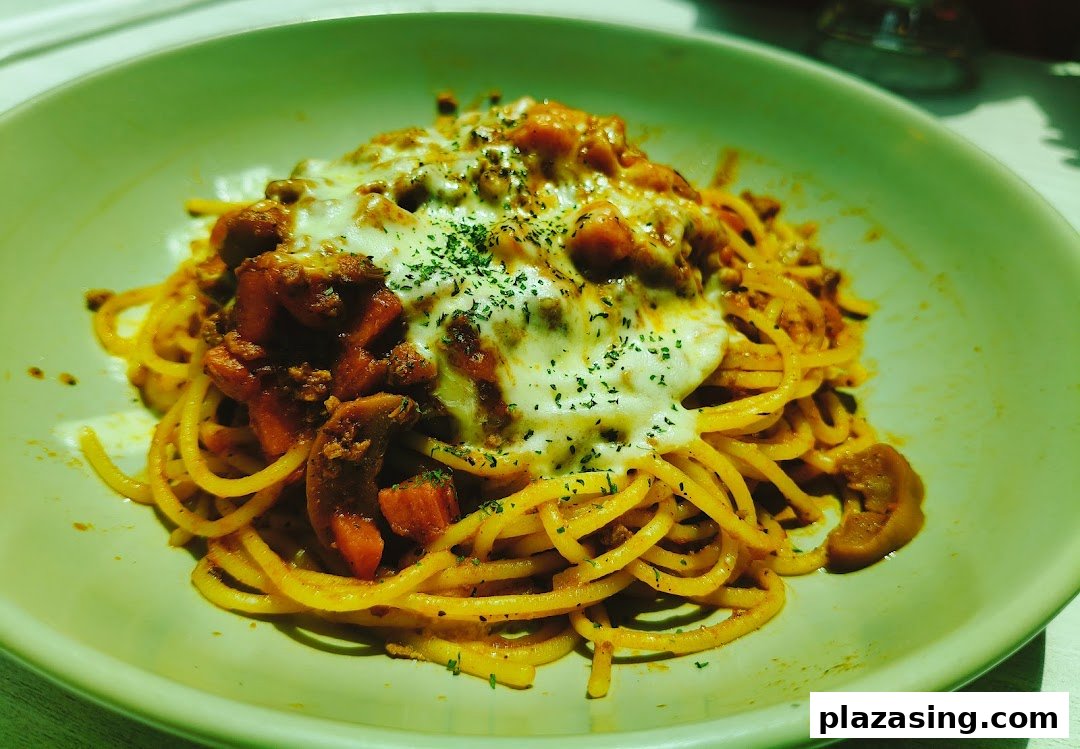 A delicious plate of spaghetti bolognese topped with melted cheese and herbs.