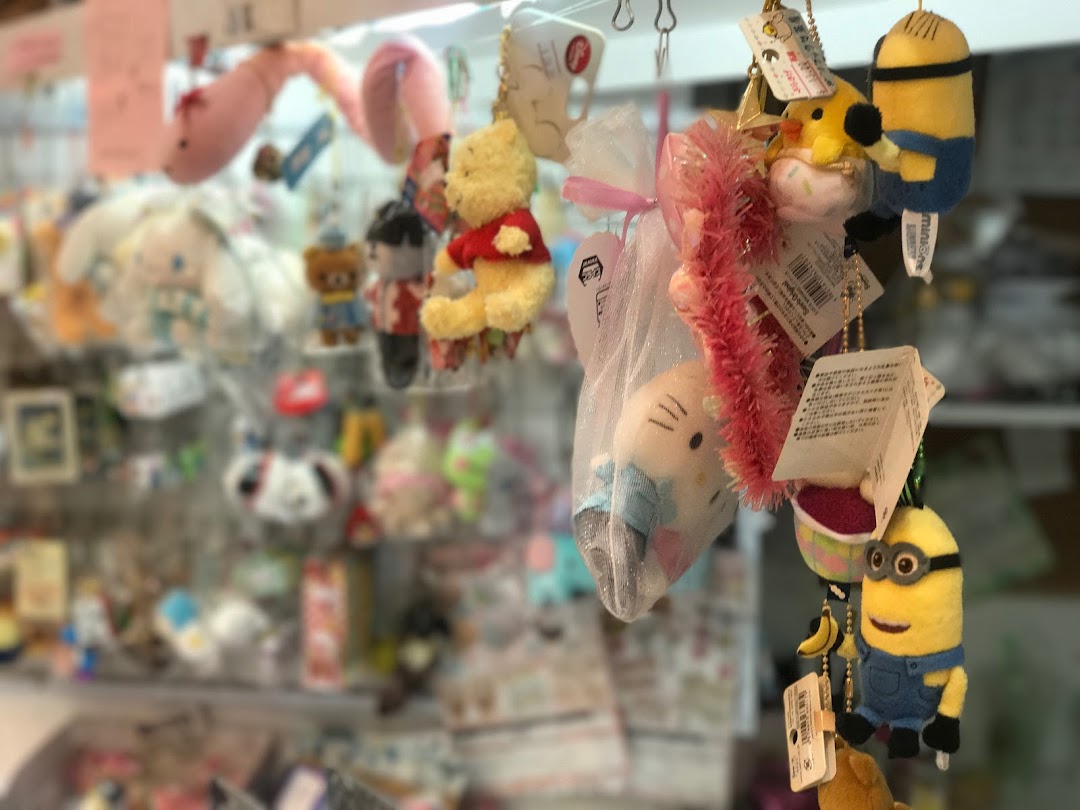A close-up of various cute plush keychains and small character merchandise hanging in a retail store.