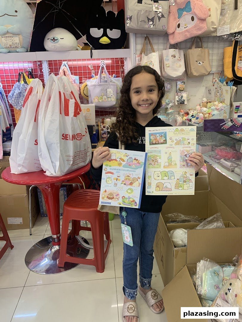 A young girl smiles while holding Sumikko Gurashi merchandise inside a vibrant retail store.
