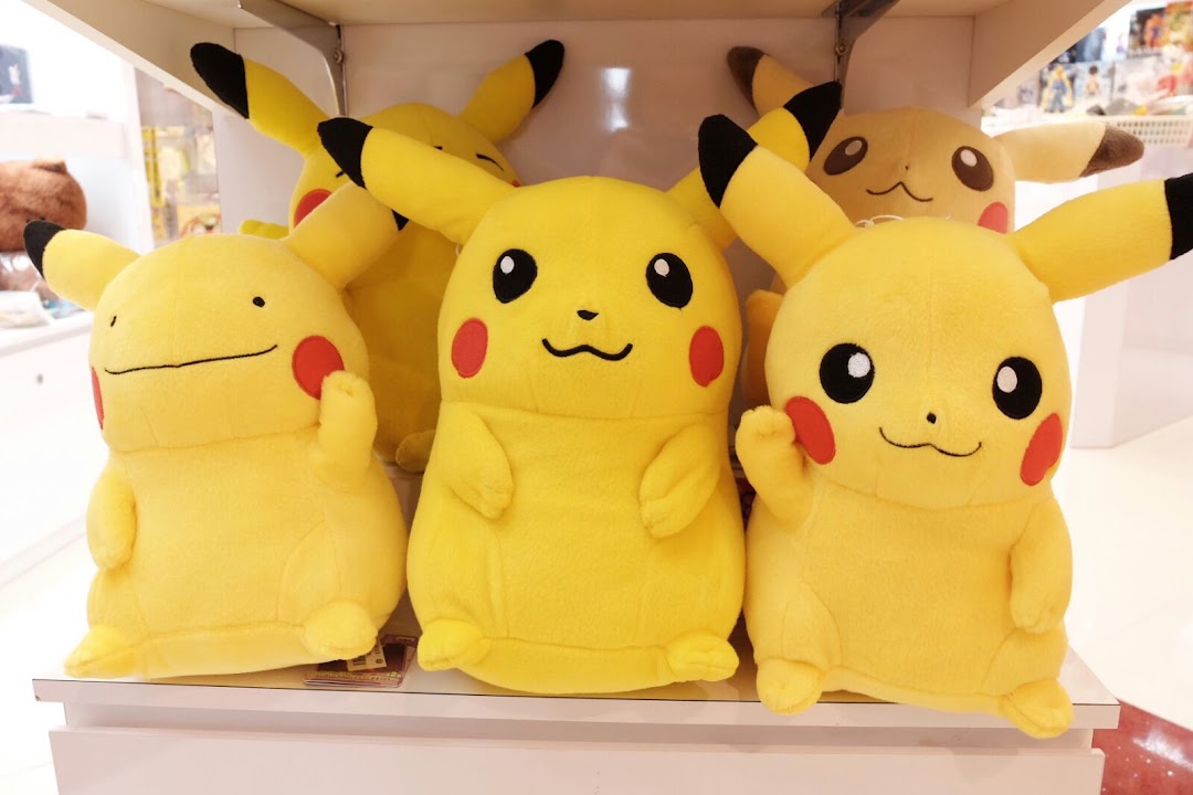 A vibrant display of various yellow Pikachu plush toys on a retail shelf.