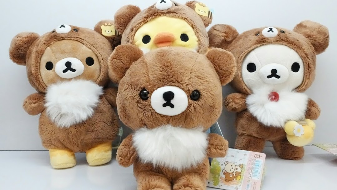 A group of adorable Rilakkuma and Korilakkuma plush toys, some in bear costumes.