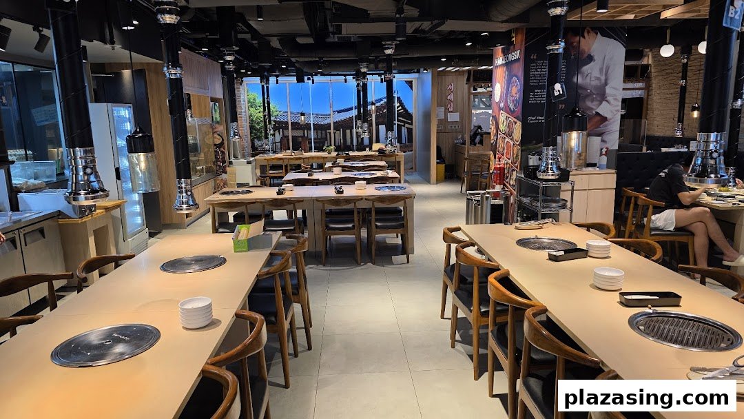 Spacious interior of a Korean BBQ restaurant featuring multiple tables with built-in grills and traditional decor.