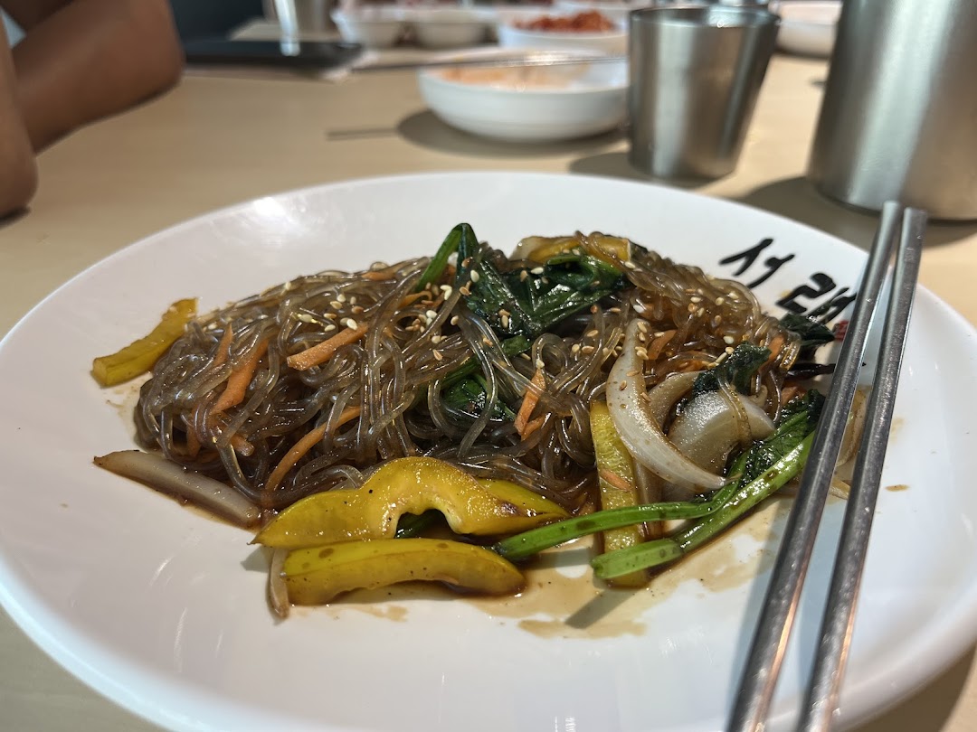 A delicious plate of Korean glass noodles (Japchae) with vegetables and sesame seeds.