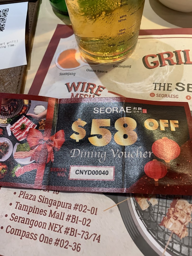 A Seorae Jib dining voucher for $58 off, displayed on a table with a drink and placemat.