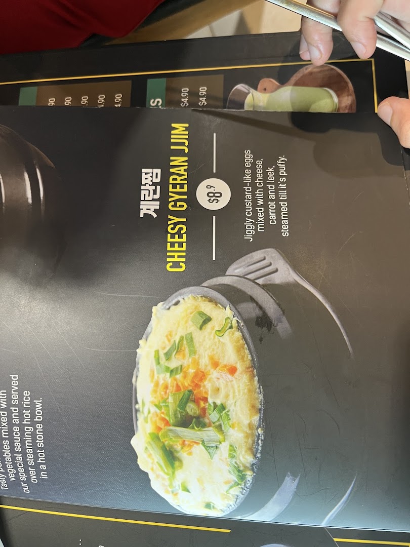 A close-up of a menu page featuring Cheesy Gyeran Jjim with its description and price.