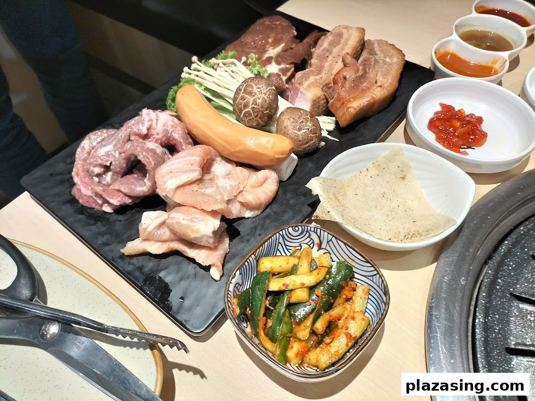 A vibrant platter of raw meats, sausage, mushrooms, and side dishes ready for grilling at a Korean BBQ restaurant.