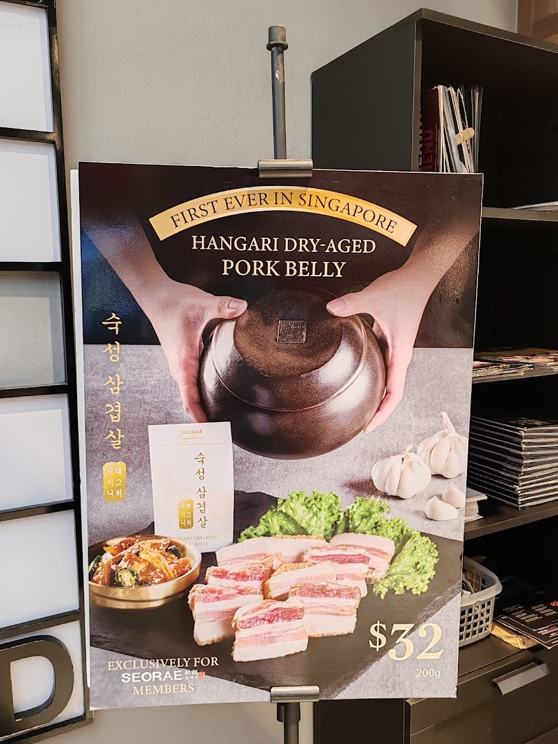 A promotional standee showcasing Seorae Jib's Hangari Dry-Aged Pork Belly, priced at $32 for 200g.
