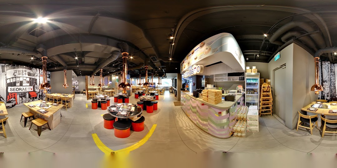 A wide-angle view of Seorae Jib's modern Korean BBQ restaurant interior with various seating arrangements.