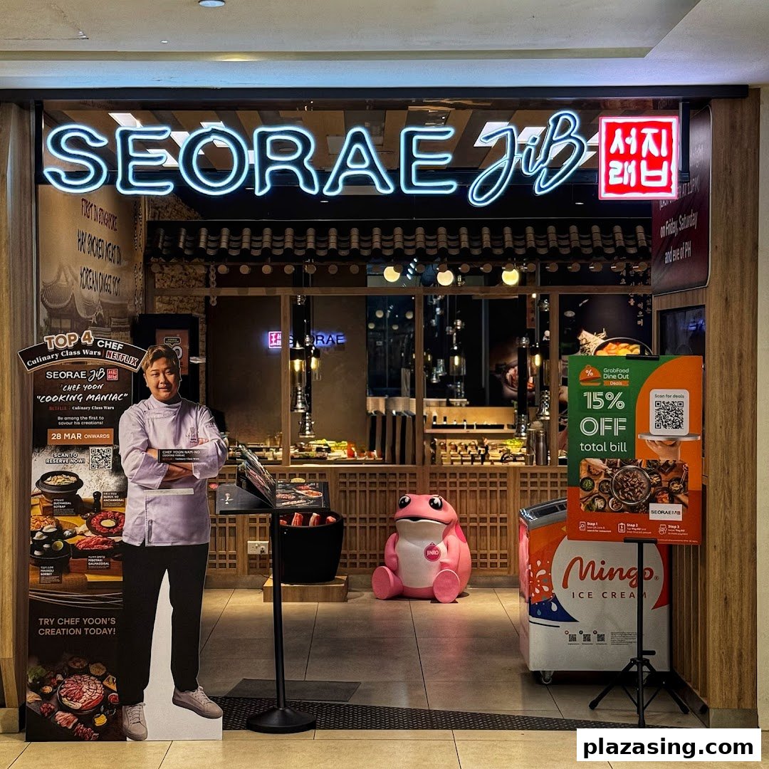 The vibrant storefront of Seorae Jib, a Korean restaurant, featuring promotional displays and a chef cutout.