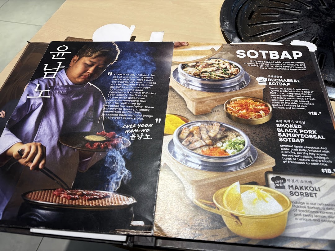 An open menu from SEORAE JIB, showcasing Korean dishes like SOTBAP and a chef's philosophy.