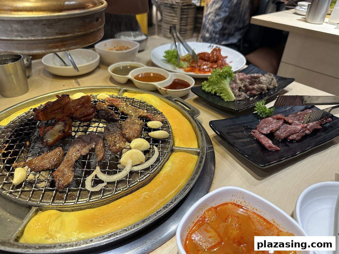 Delicious Korean BBQ grilling on a tabletop, surrounded by various side dishes and fresh meats.