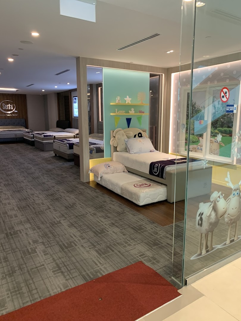 Interior view of Serta Sleep Center showcasing various mattresses and beds, including a children's sleep display.