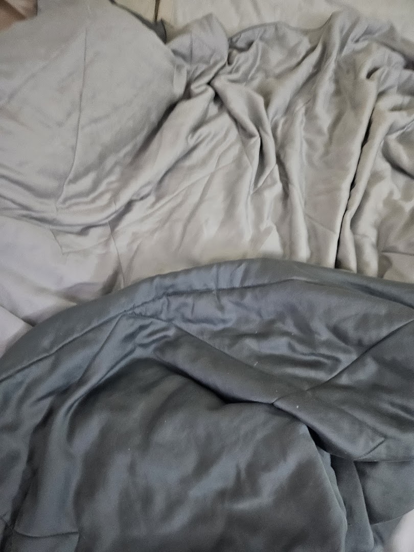 Close-up of soft, grey bedding or comforter, showcasing fabric texture and comfort.