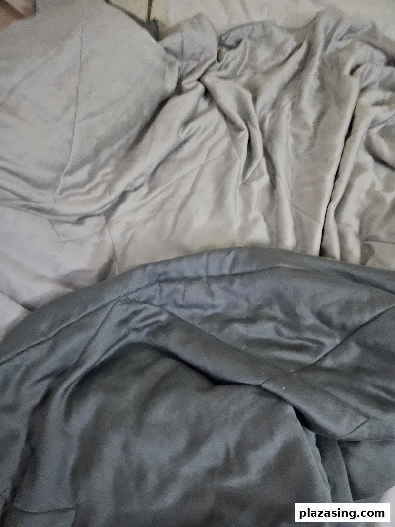Close-up of soft, grey bedding or comforter, showcasing fabric texture and comfort.
