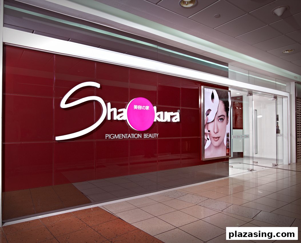 The vibrant red storefront of Shakura Pigmentation Beauty with a prominent logo and a beauty advertisement.