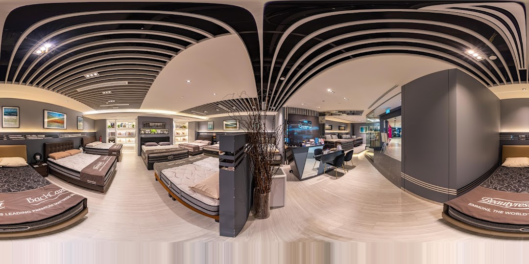 A wide-angle view of the Simmons Studio showroom, showcasing various premium mattresses and bed setups.