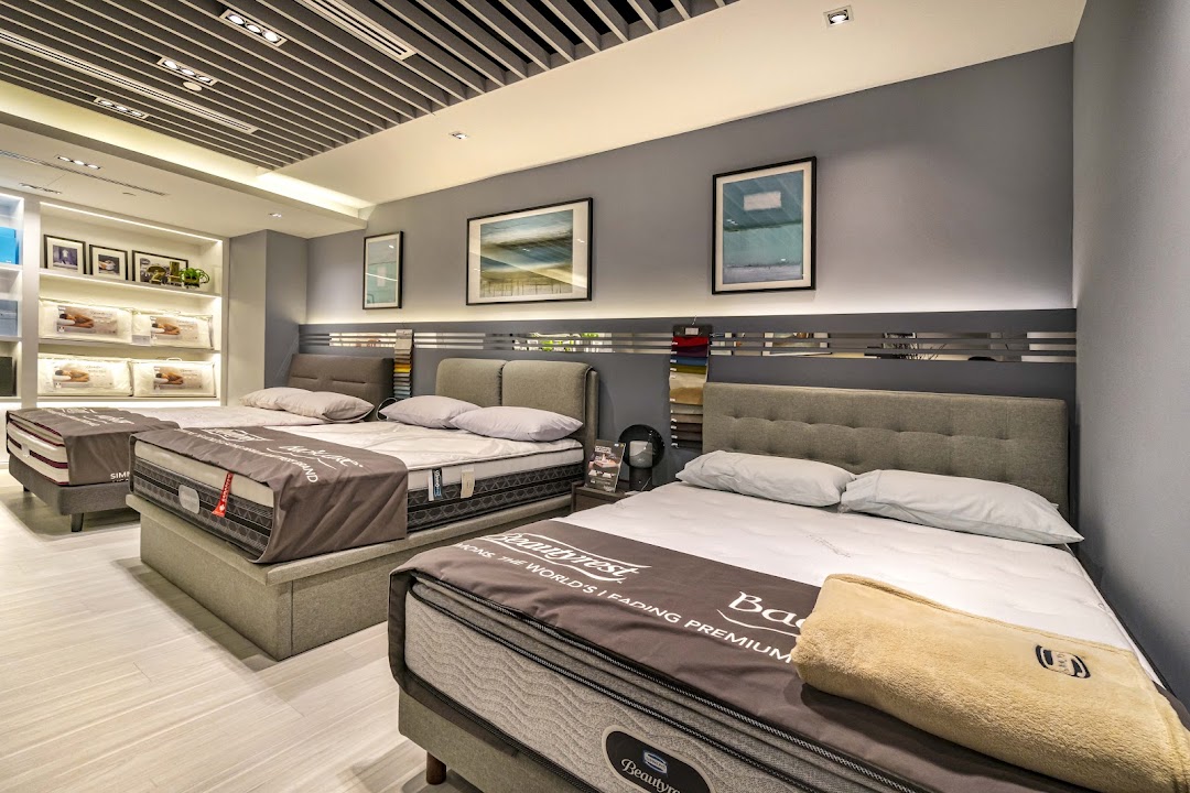 An interior view of Simmons Studio, showcasing multiple premium mattresses and bedding displays.
