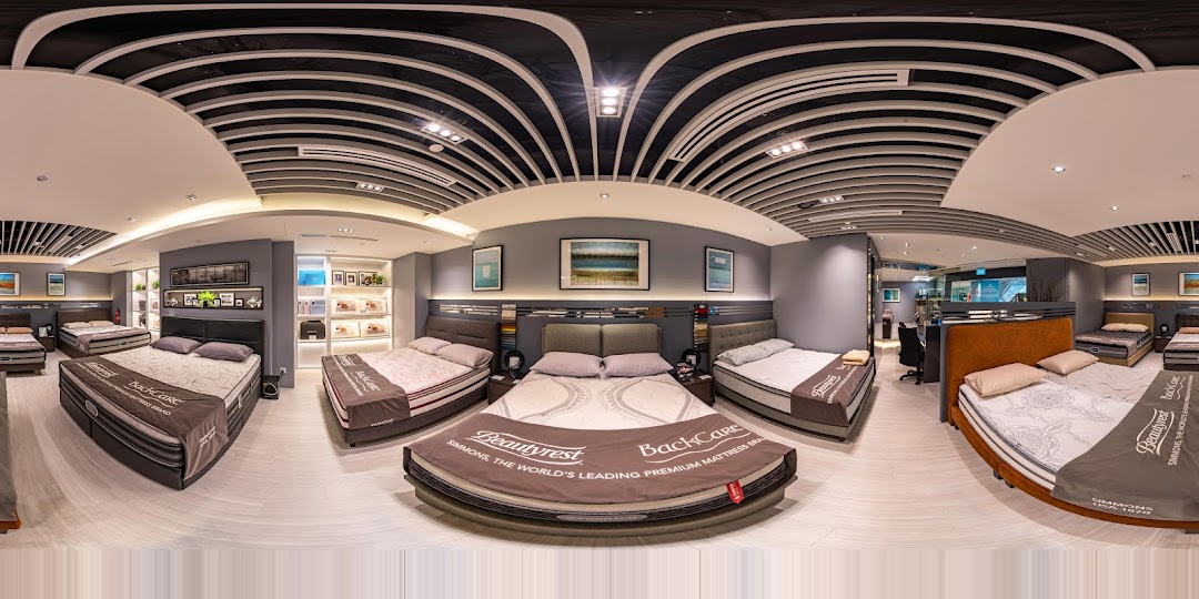 An interior view of Simmons Studio, showcasing various premium mattresses and bed frames in a modern showroom.