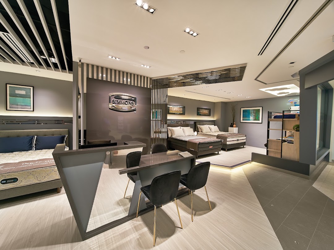 Interior view of Simmons Studio showcasing various premium mattresses and bedroom furniture displays.
