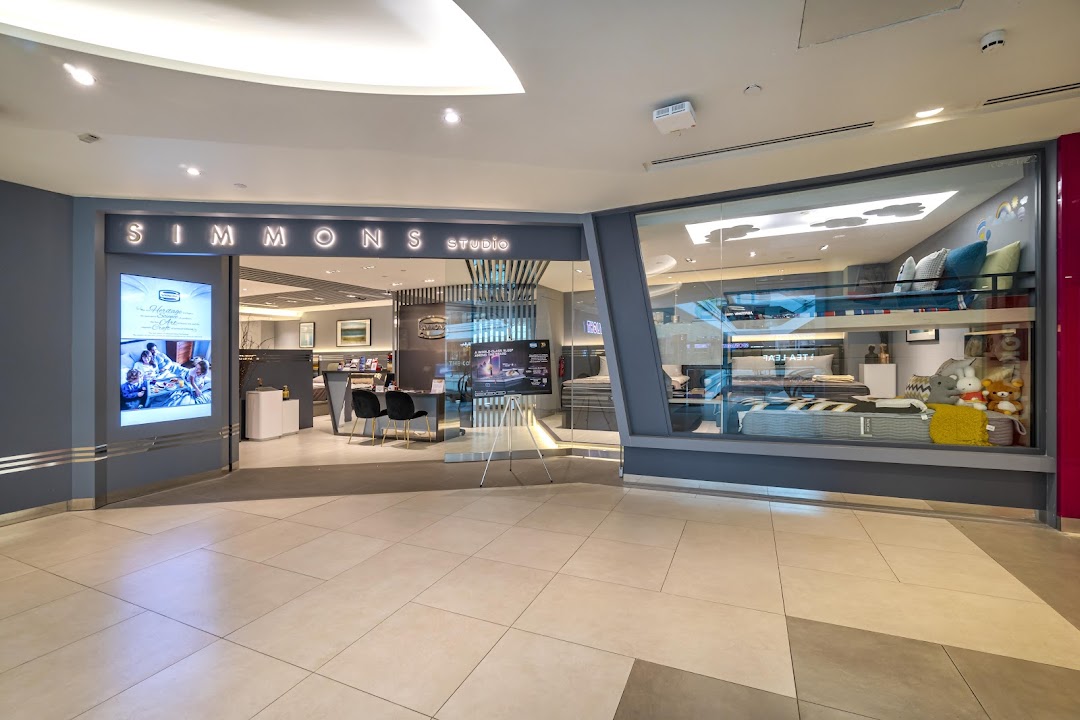 The exterior of Simmons Studio, a bedding and mattress store, featuring its entrance and display windows.