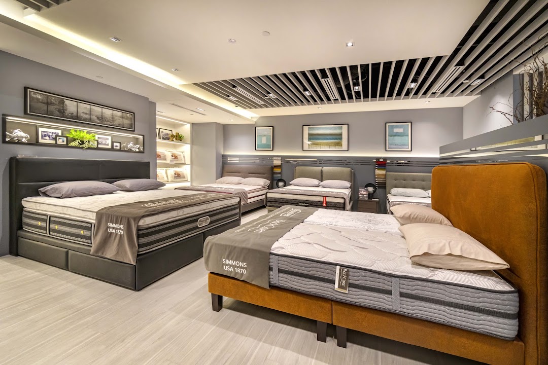 An interior view of Simmons Studio, showcasing various beds and mattresses in a modern showroom.