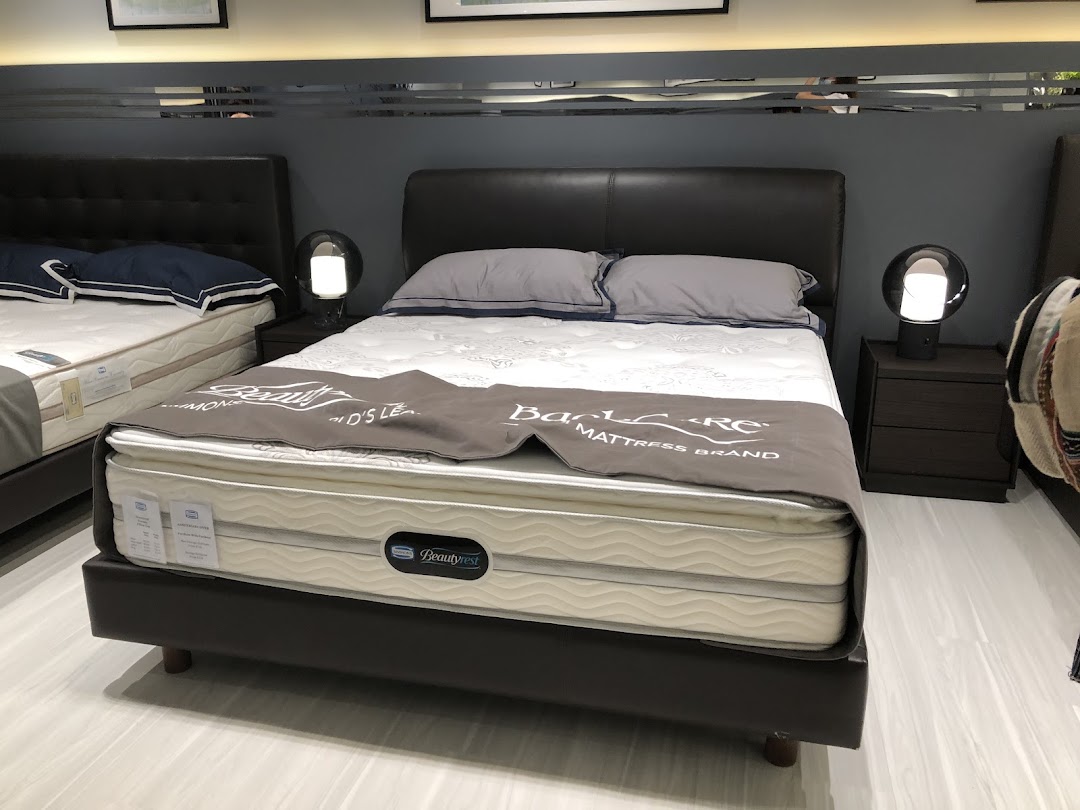 A showroom display featuring multiple beds with mattresses, showcasing comfort and quality sleep solutions.