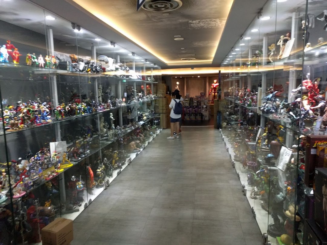 An interior view of Simply Toys, showcasing extensive collections of action figures and statues in glass display cases.