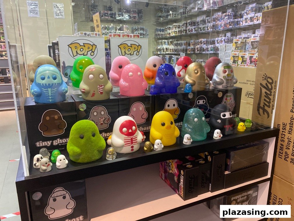 A vibrant display of collectible figures, including 'Tiny Ghost' and Funko Pop! boxes, inside a toy shop.