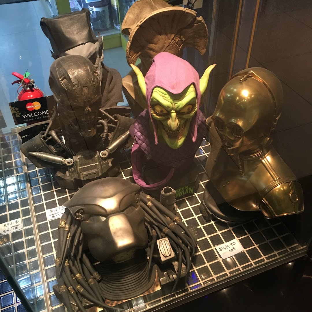 A display of detailed character busts including Green Goblin, C-3PO, and Predator in a retail shop.