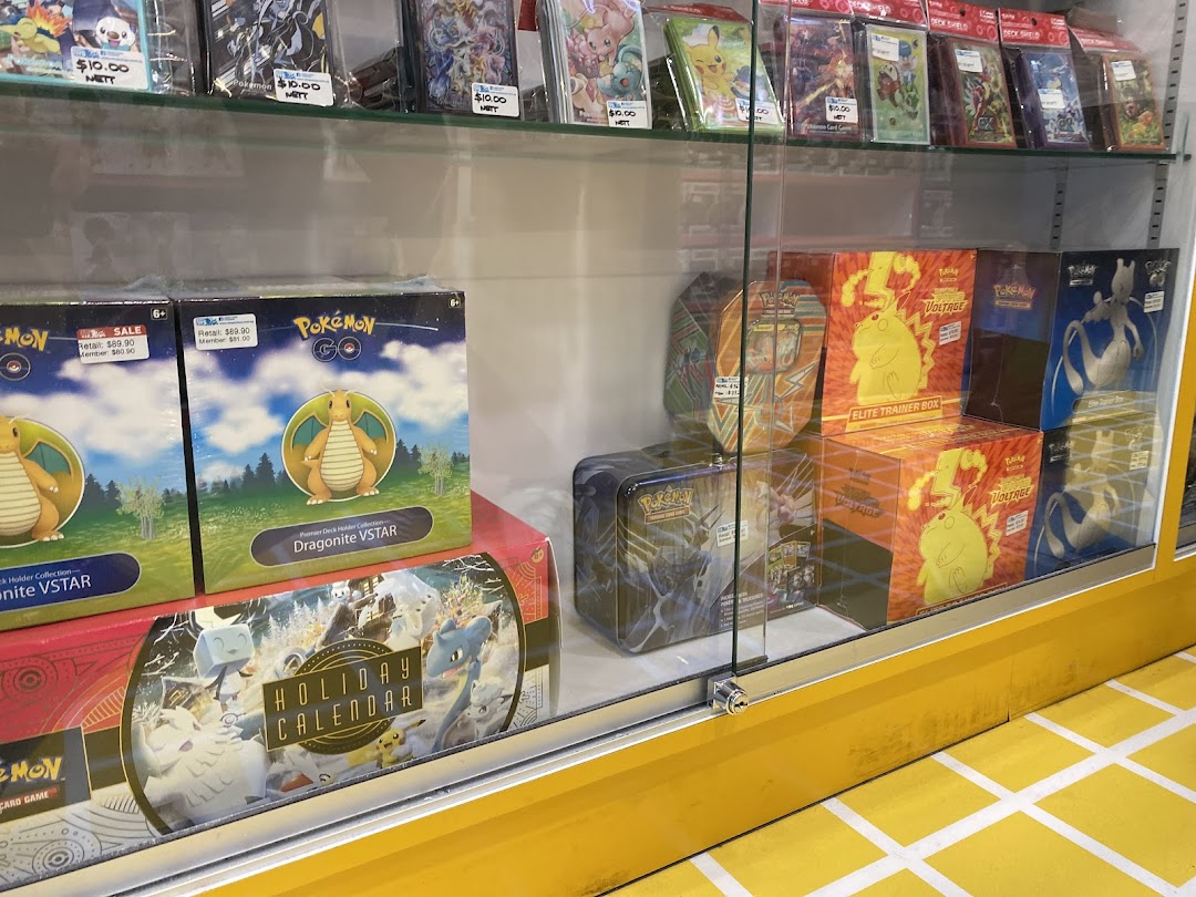 A glass display case at Simply Toys showcasing a variety of Pokémon Trading Card Game products and collectibles.
