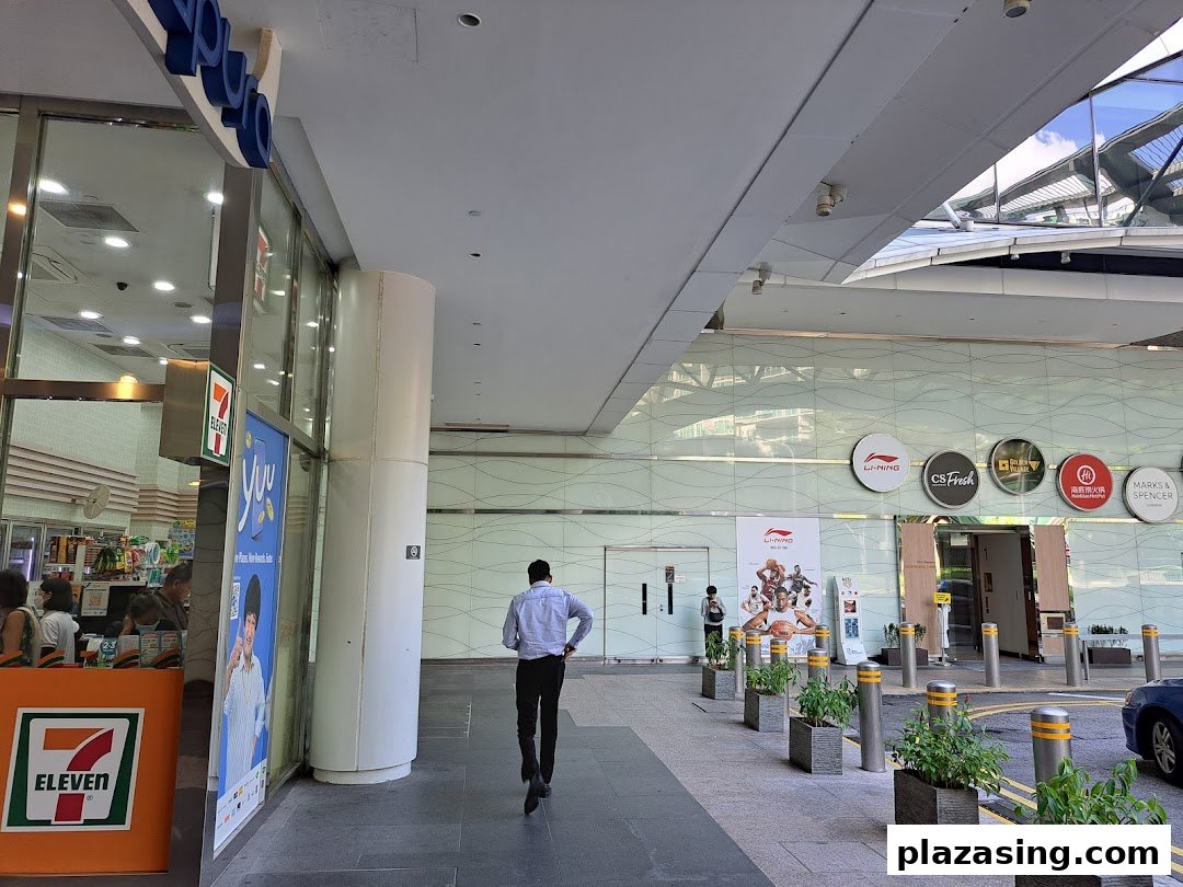 The exterior of a 7-Eleven convenience store at Plaza Singapura, with a person walking past.