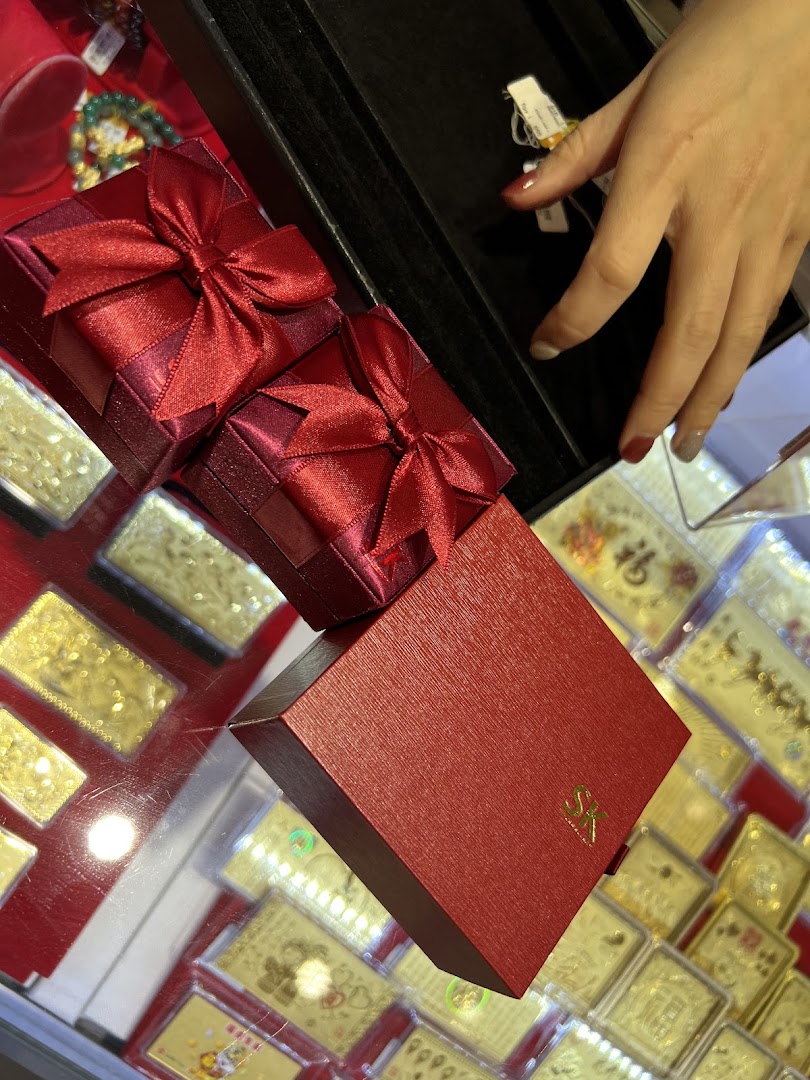 Elegant red gift boxes with bows, showcasing jewellery packaging and gold items at SK Jewellery.