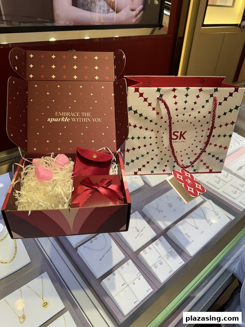 An open gift box, SK Jewellery shopping bag, and sparkling jewellery displays inside the store.