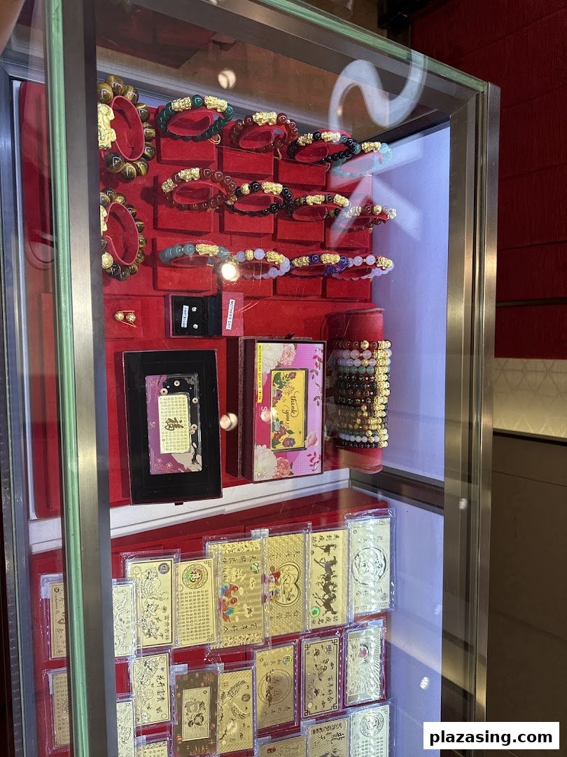 A glass display case showcasing an array of traditional and modern jewellery, including bracelets and gold-plated items.