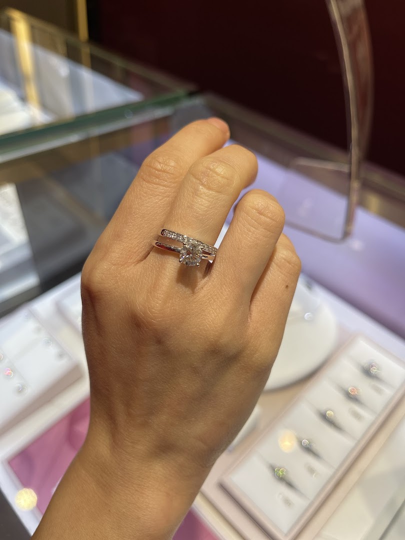A hand models a dazzling diamond engagement and wedding ring set from SK Jewellery.