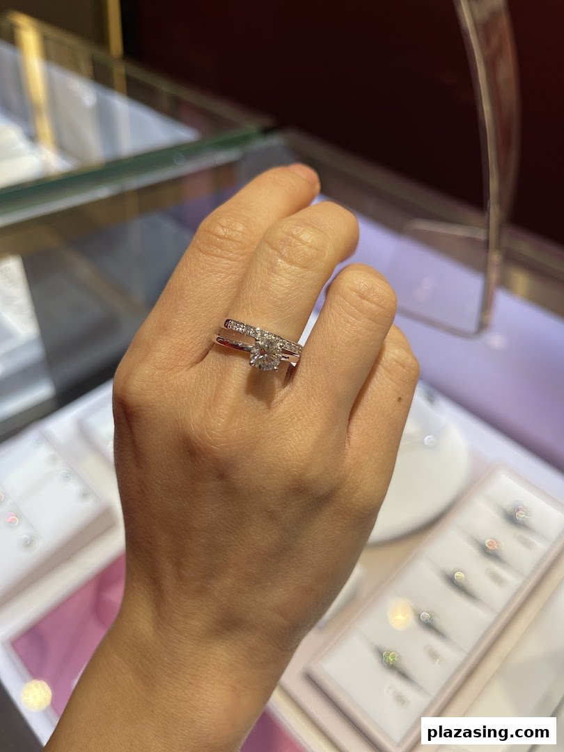 A hand models a dazzling diamond engagement and wedding ring set from SK Jewellery.