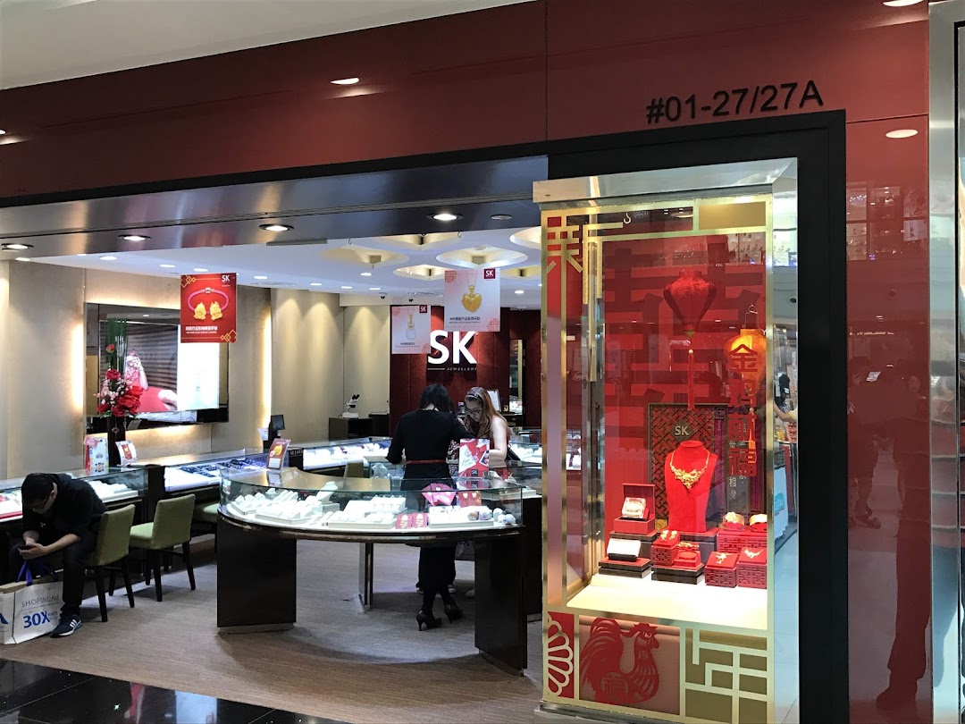 The image captures the inviting entrance of SK Jewellery, showcasing elegant displays and customers browsing exquisite pieces.