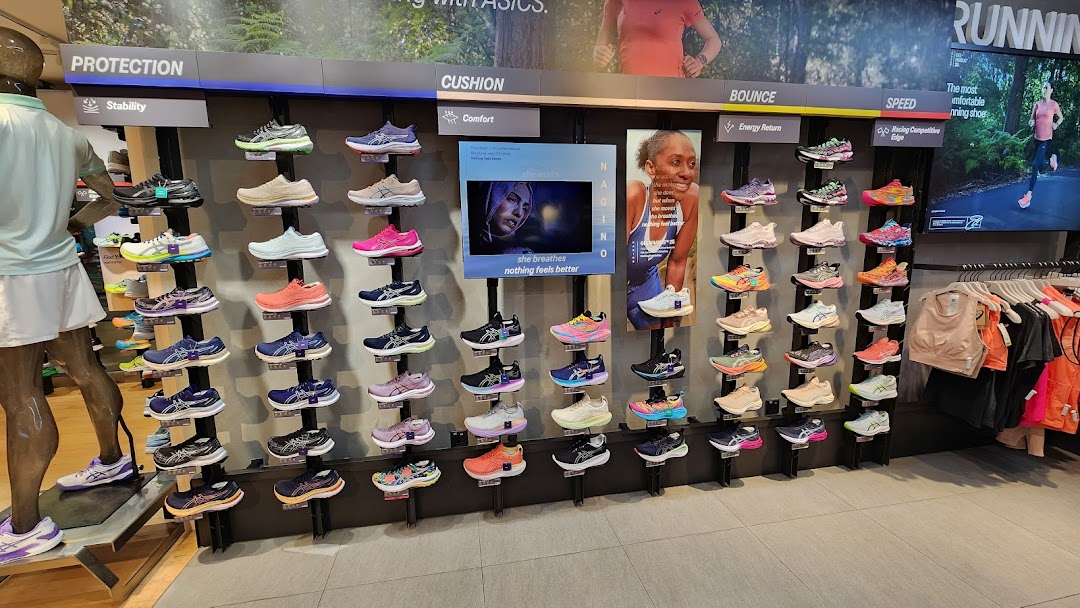 A vibrant display of ASICS running shoes categorized by performance features like protection, cushion, bounce, and speed.