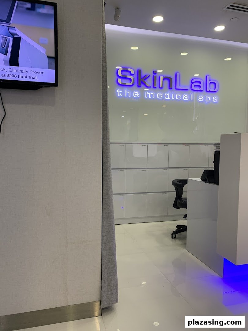 Interior view of SkinLab The Medical Spa reception area, featuring its illuminated logo and a screen displaying an offer.