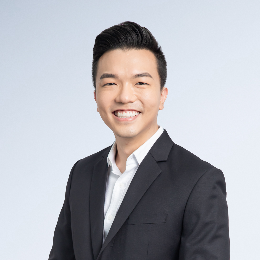 A professional headshot of a smiling man in a black suit and white shirt.