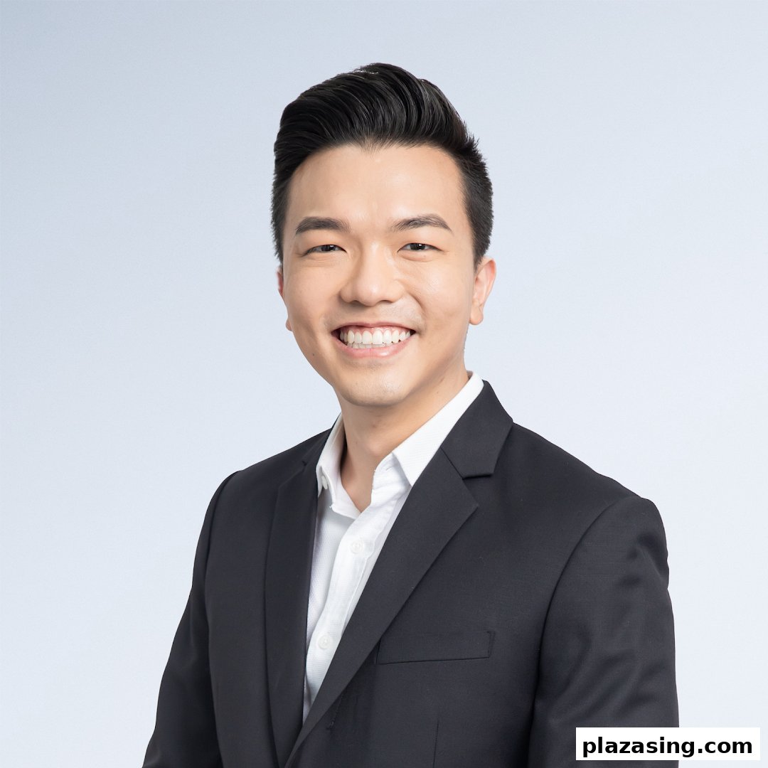 A professional headshot of a smiling man in a black suit and white shirt.