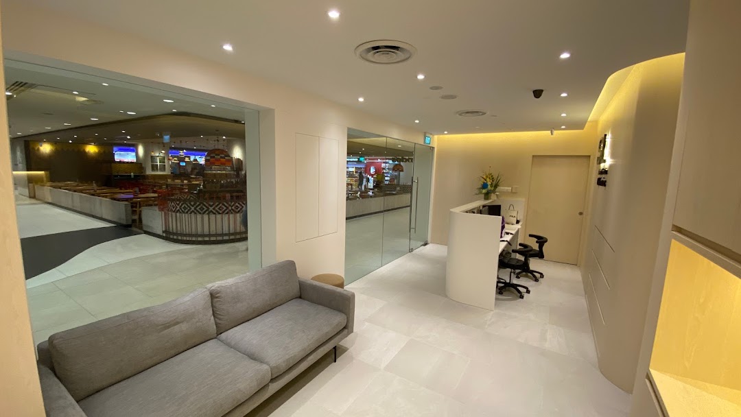 A modern and inviting waiting area with a comfortable sofa and reception desk at SL Aesthetic Clinic.