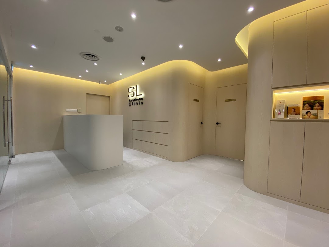 The modern and inviting reception area of SL Aesthetic Clinic with a sleek desk and warm lighting.