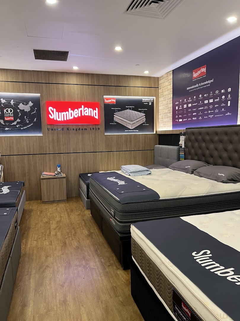 Interior view of a Slumberland bedding store showcasing various mattresses and bed frames.