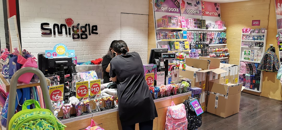 Interior view of a Smiggle store with a staff member at the counter and colorful stationery products.